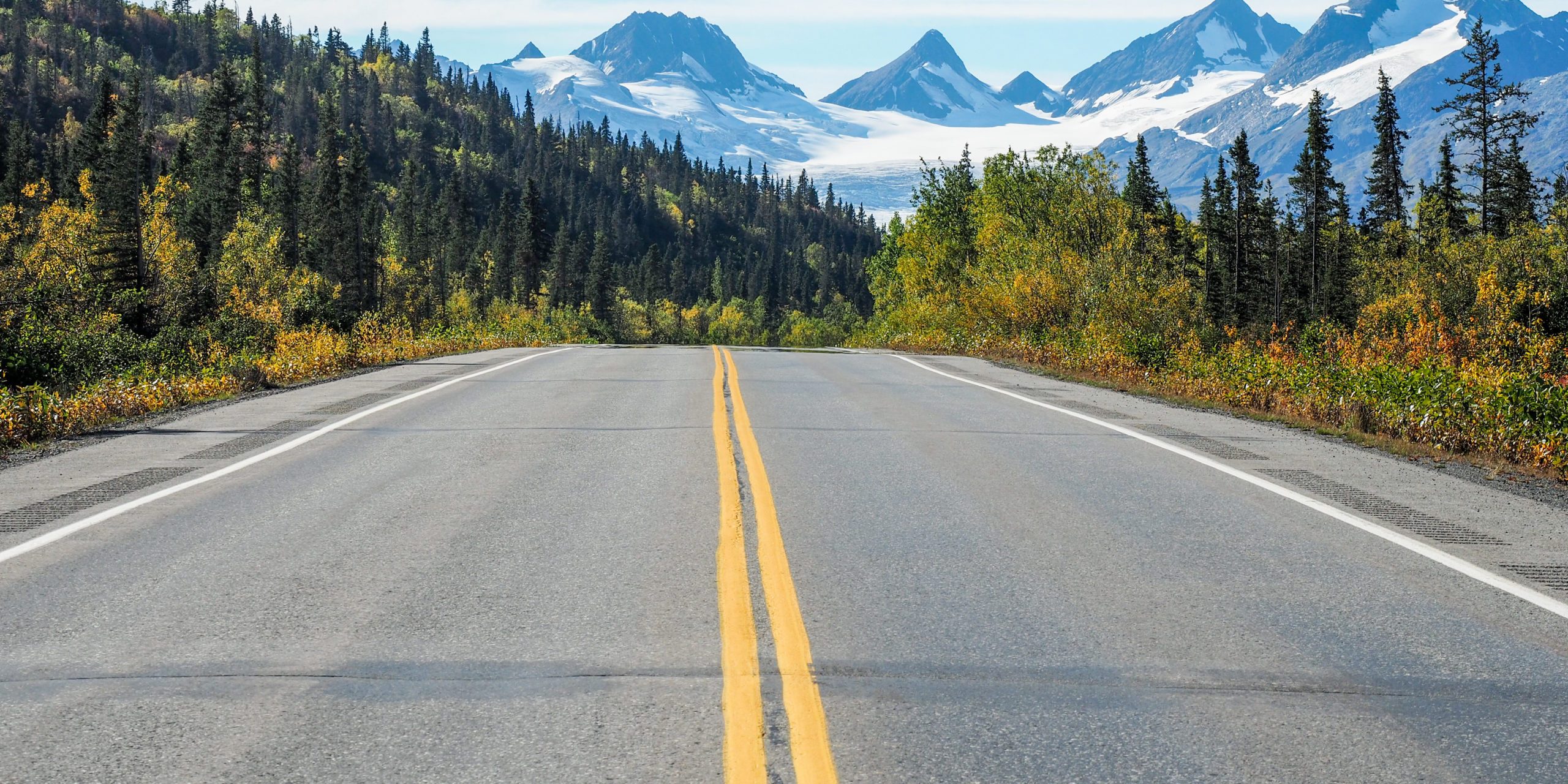 asphaltstrasse-mit-gelben-linien-und-dem-worthington-gletscher-in-alaska-scaled-1